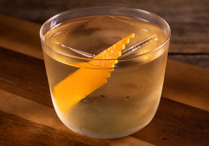 Drinque de uísque com Jerez em copo baixo enfeitado com uma casca de laranja.