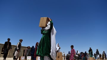 Em imagem de maio de 2020,afegã carrega ajuda humanitária distribuída no campo de deslocados internos nos arredores de Mazar-i-Sharif. Foto: Farshad Usyan/AFP
