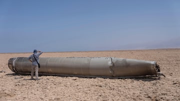 Um jornalista observa o míssil iraniano que caiu no Mar Morto, em Israel 

