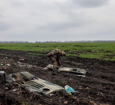 A Ukrainian soldier looks at a part of a destroyed Russian military vehicle, amid Russia's attack on Ukraine, in the village of Husarivka, in Kharkiv region, Ukraine, April 14, 2022. Picture taken April 14, 2022. REUTERS/Alkis Konstantinidis