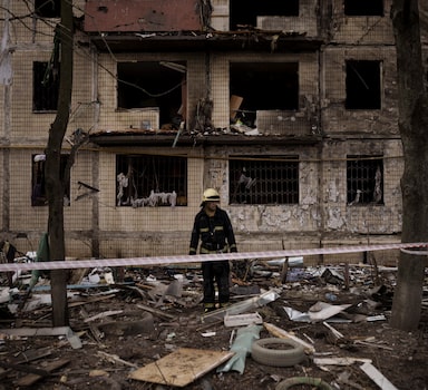 A Ukrainian firefighter walks outside a destroyed building after it was hit by artillery shelling in Kyiv in Kyiv, Ukraine, Monday, March 14, 2022. (AP Photo/Felipe Dana)