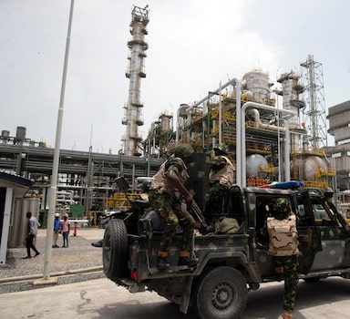 Nigerian soldiers wait at a newly inaugurated Dangote fertilizer plant in Lagos, Nigeria, Tuesday, March. 22, 2022. Nigeria is eyeing global exports of fertilizer with a $2.5 billion plant inaugurated on Tuesday, a facility which the nation's leader said would contribute to the global supply amid the shock waves from Russia, a major global supplier, where an ongoing war with Ukraine has disrupted supplies. (AP Photo/Sunday Alamba)