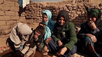Aziz Gul (de blusa verde, nocentro)comsua filha Qandi, de 10 anos (a terceira da esquerda para a direita, de lenço azul na cabeça); o pai vendeu a menina e fugiu ao ser descoberto. Foto: Mstyslav Chernov/AP