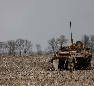 Soldado ucraniano caminha ao redor de um tanque russo queimado nos arredores de Kiev