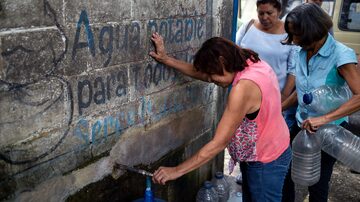 Com desabastecimento que dura várias semanas, moradores de San Juan de los Morros, na Venezuela, recorrem a poço artesiano instalado no centro da cidade. Foto: AFP PHOTO / Federico PARRA