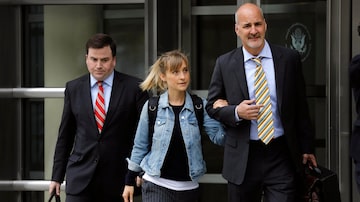 A atriz de 'Smallville' Allison Mack deixa o tribunal acompanhada de seus advogados. Foto: Peter Foley/EFE