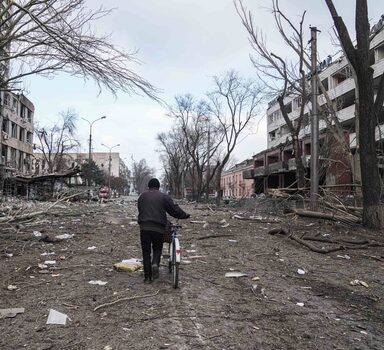 Ucraniano passa por destroços deixados por ataques russos em Mariupol