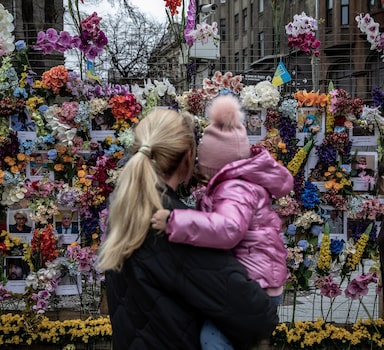 People visit a memorial for civilians killed during the Russian invasion of Ukraine, in Lvivi, Ukraine, on Sunday, April 24, 2022. (Finbarr O'Reilly/The New York Times)
