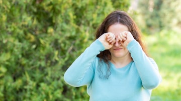 Woman suffering itching scratching eyes in a park. Foto: cunaplus/Adobe Stock 