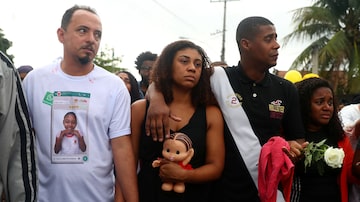 Adegilson Félix (de camiseta branca) e Vanessa Francisco Sales, pais da menina Ágatha Sales Félix, durante o enterro da filha. Foto: Pilar Olivares/Reuters