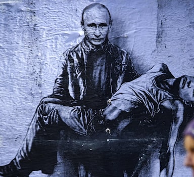 Mulher passa por mural que retrata o presidente Vladimir Putin segurando seu próprio corpo, em Sofia