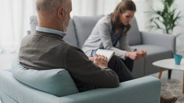 Depressed woman talking during a therapy session, the psychologist is writing notes and listening. Foto: StockPhotoPro/Adobe Stock