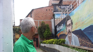 Fotógrafo Edgar Jiménez observa mural de boas vindas no bairro de Pablo Escobar, em Medellín; história do traficante se mistura com a da cidade. Foto: Washington Post photo by Samantha Schmidt