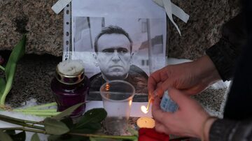 A person lights a candle next to a portrait of Russian opposition leader Alexei Navalny at the monument to the victims of political repressions following Navalny's death, in Saint Petersburg, Russia February 16, 2024. REUTERS/Stringer. Foto: Reuters