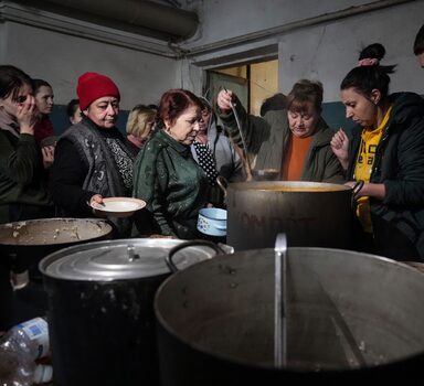 People queue to receive hot food in a improvised bomb shelter in Mariupol, Ukraine, Monday, March 7, 2022. (AP Photo/Evgeniy Maloletka)