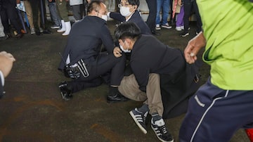 A man, on the ground, who threw what appeared to be a smoke bomb, is caught at a port in Wakayama, western Japan Saturday, April 15, 2023. Japan’s NHK television reported Saturday that a loud explosion occurred at the western Japanese port during Prime Minister Fumio Kishida’s visit, but there were no injuries. (Kyodo News via AP). Foto: Kyodo News via AP