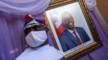 A man stands next to a portrait of slain Haitian President Jovenel Moise placed on a memorial at the city hall in Cap-Haitien, Haiti July 22, 2021. REUTERS/Ricardo Arduengo