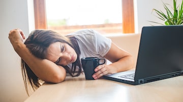 Tired businesswoman sleeping on table in office. Young exhausted girl working from home. Woman using laptop. Entrepreneur, business, freelance work, student, stress, work from home concept. Foto: tutye/Adobe Stock 