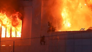 Incêndio atinge hotel-cassino Grand Diamond City, em Poipet, nesta quinta-feira, 29. Ao menos 10 pessoas morreram. Fotos mostram grupos desesperadamente amontoados nas bordas do prédio enquanto as chamas os cercam. Foto: AFP
