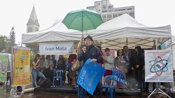 Hernan Chaimovich, professor do Instituto de Química da USP, discursa debaixo de chuva na Marcha pela Ciência em São Paulo, no Largo da Batata; cerca de 300 pessoas participaram do evento neste sábado, 22. Foto: Herton Escobar/Estadão