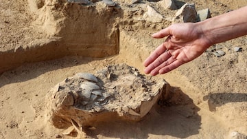 Lauren Davis, excavation manager of the southern district at the Israel Antiquities Authority (IAA), shows discovered ostrich egg fragments dating over 4000 years old next to an ancient fire pit at a site in the dunes near Nitzana along the Israel-Egypt border in the western Negev desert on January 12, 2023. (Photo by GIL COHEN-MAGEN / AFP). Foto: Gil Cohen-Magen/AFP