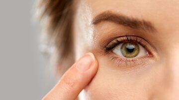 vision, beauty and people concept - close up of woman pointin finger to eye. Foto: Syda Productions/Adobe Stock