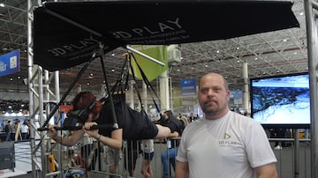 O publicitário Rodrigo Oliva, 42, ao lado do simulador de asa delta que está exibindo na Campus Party 2018. Foto: Bruno Capelas/Estadão