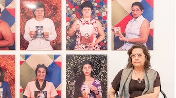 A artista e seus retratos de anônimos em uma das séries em exposição. Foto: DANIEL TEIXEIRA/ ESTADAO