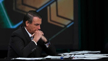 Brazilian President and presidential candidate Jair Bolsonaro looks at his desk full of papers during an interview televised by SBT broadcaster in Osasco, metropolitan area of Sao Paulo, Brazil, on October 21, 2022. - Veteran leftist Luiz Inacio Lula da Silva said on October 20 he is keeping an eye on poll numbers showing his lead narrowing over far-right incumbent Jair Bolsonaro for Brazil's October 30 presidential runoff, but confident he will win. (Photo by Nelson ALMEIDA / AFP). Foto: Nelson Almeida/AFP