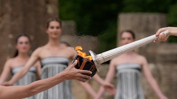 Actress Mary Mina, playing high priestess, right, lights a torch during the official ceremony of the flame lighting for the Paris Olympics, at the Ancient Olympia site, Greece, Tuesday, April 16, 2024. The flame will be carried through Greece for 11 days before being handed over to Paris organizers on April 26. (AP Photo/Thanassis Stavrakis). Foto: Thanassis Stavrakis/AP