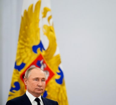 Russian President Vladimir Putin listens to the national anthem after delivering his speech during an awarding ceremony for the Russian Olympic Committee medalists of the XXIV Olympic Winter Games in Beijing and members of the Russian Paralympic team, at the Kremlin in Moscow, Russia, Tuesday, April 26, 2022. (AP Photo/Alexander Zemlianichenko)