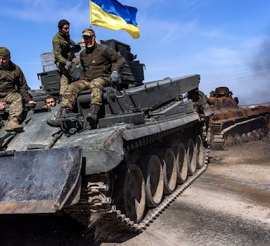 Soldados ucranianos rebocam um tanque russo danificado em um campo perto da vila de Lypivka, a oeste de Kiev; Rússia pede que governo Biden interrompa envio de armas avançadas para a Ucrânia