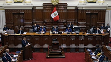 O primeiro-ministro do Peru, Gustavo Adrianzen (esq.), discursa no Congresso para pedir um voto de confiança para permitir que a presidente Dina Boluarte permaneça no cargo apesar do escândalo dos relógios de luxo