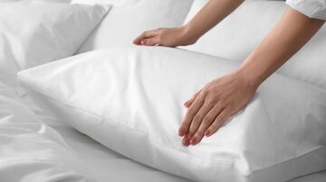 Woman fluffing soft pillow in bedroom, closeup. Foto: New Africa/Adobe Stock            