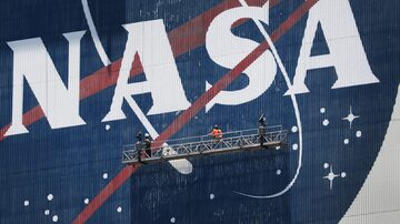 (FILES) Workers freshen up the paint on the NASA logo at the Kennedy Space Center in Cape Canaveral, Florida, on May 20, 2020. Scientists at NASA's first ever public meeting on "unidentified anomalous phenomena" -- more commonly called UFOs -- called on May 31, 2023, for a more rigorous scientific approach to clarify the origin of hundreds of mysterious sightings. (Photo by JOE RAEDLE / GETTY IMAGES NORTH AMERICA / AFP)