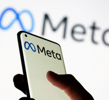 FILE PHOTO: Woman holds smartphone with Meta logo in front of a displayed Facebook's new rebrand logo Meta in this illustration picture taken October 28, 2021. REUTERS/Dado Ruvic/Illustration/File Photo/File Photo