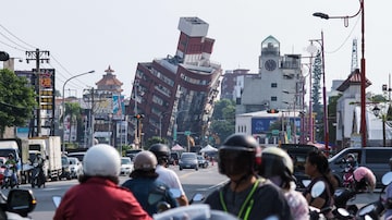 Residentes passam por um edifício danificado causado pelo terremoto em Hualien em 4 de abril de 2024. Pelo menos nove pessoas morreram e mais de mil ficaram feridas no abalo sísmico em Taiwan que danificou dezenas de edifícios e também gerou alerta de tsunami até no Japão e nas Filipinas.