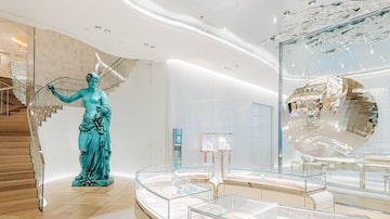 Ao lado de vitrines cheias de anéis de noivado estão 'Bronze Eroded Venus of Arles' (2022) de Daniel Arsham, à esquerda, e “Random Triangle Mirror” (2016) de Anish Kapoor à direita, no terceiro andar da loja principal da Tiffany na Quinta Avenida.