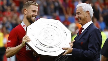 Jordan Henderson, capitão do Liverpool, recebe a taça da Supercopa da Inglaterra das mãos de Ian Rush, lenda do clube. Foto: Reuters/Andrew Boyers