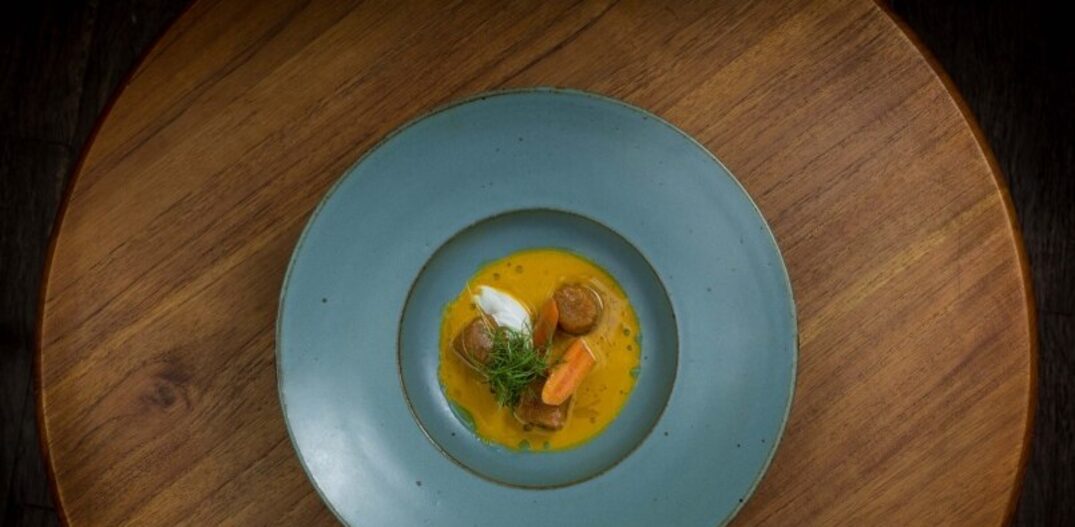 Para começar o leve nhoque de cenoura servido em sopa morna de cenoura, com pedaços de cenoura em conserva e uma farofa de rapadura e castanha de caju. Foto: Raphael Criscuolo
