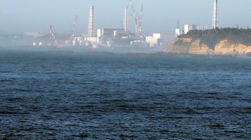 The Fukushima Daiichi nuclear power plant, damaged by a massive March 11, 2011, earthquake and tsunami, is seen from the nearby Ukedo fishing port in Namie town, northeastern Japan, Thursday, Aug. 24, 2023. The tsunami-wrecked Fukushima Daiichi nuclear power plant's operator says it began releasing its first batch of treated radioactive water into the Pacific Ocean on Thursday — a controversial step that prompted China to ban seafood from Japan.(AP Photo/Eugene Hoshiko). Foto: Eugene Hoshiko/AP