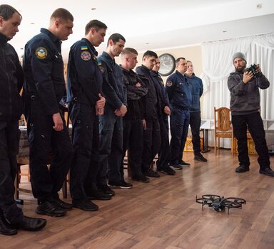 O piloto de drones Chase Bailey explica aos membros do serviço de emergência ucraniano como operar o drone Lemur