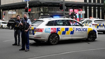 Armed New Zealand police officer stand at a road block in the central business district following a shooting in Auckland, New Zealand, Thursday, July 20, 2023. New Zealand police are responding to reports that a gunman has fired shots in a building in downtown Auckland. (AP Photo/Abbie Parr)