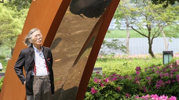 O artista nipo-brasileiro Yutaka Toyota ao lado de sua obra. Foto: Gianni Toyota