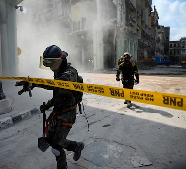 Equipes de resgate retiram corpos das ruínas de um hotel de luxo em Havana destruído em uma explosão.