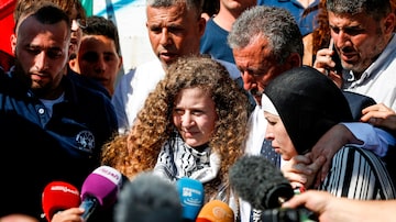 A adolescente palestina Ahed Tamimi (c), acompanhada de seus pais, fala com a imprensa após ter sido libertada de uma prisão israelense. Foto: Abbas Momani/AFP