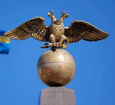 A Russian Imperial double-headed eagle is seen in front of a Sweden flag on the Czarina's Stone in the Market Square, in Helsinki, Finland, Friday, May 13, 2022. Finnish leaders announced Thursday their belief that Finland should join the world's biggest military organization because of Russia's war in Ukraine. Sweden could soon follow suit. (AP Photo/Martin Meissner)