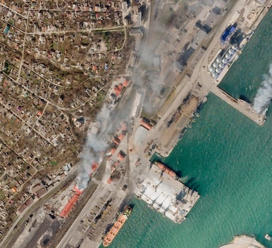 In this satellite photo from Planet Labs PBC, a Ukrainian naval vessel and a nearby building burn in the besieged city of Mariupol, Ukraine, Wednesday, April 6, 2022. The photo appears to show the Ukrainian command ship Donbas burning at the port in Mariupol, as a nearby building also burned around 2:30 p.m. local time Wednesday. A cause for the fire remained unclear. (Planet Labs PBC via AP)