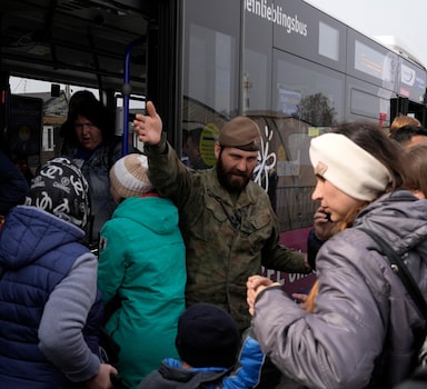 A Polish soldier gives directions to Ukrainian refugees upon their arrival at border crossing in Medyka, southeastern Poland, on Wednesday, March 30, 2022. The U.N. refugee agency says more than 4 million people have now fled Ukraine following Russia's invasion, a new milestone in the largest refugee crisis in Europe since World War II. (AP Photo/Sergei Grits)
