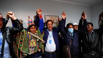 Luis Arce (ao centro) comemora ao lado do vice, David Choquehuanca (de bolsa), a vitória no primeiro turno na eleição realizada no domingo. Foto: Juan Karita/AP